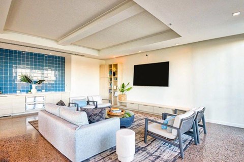 a living room with a couch and chairs and a television